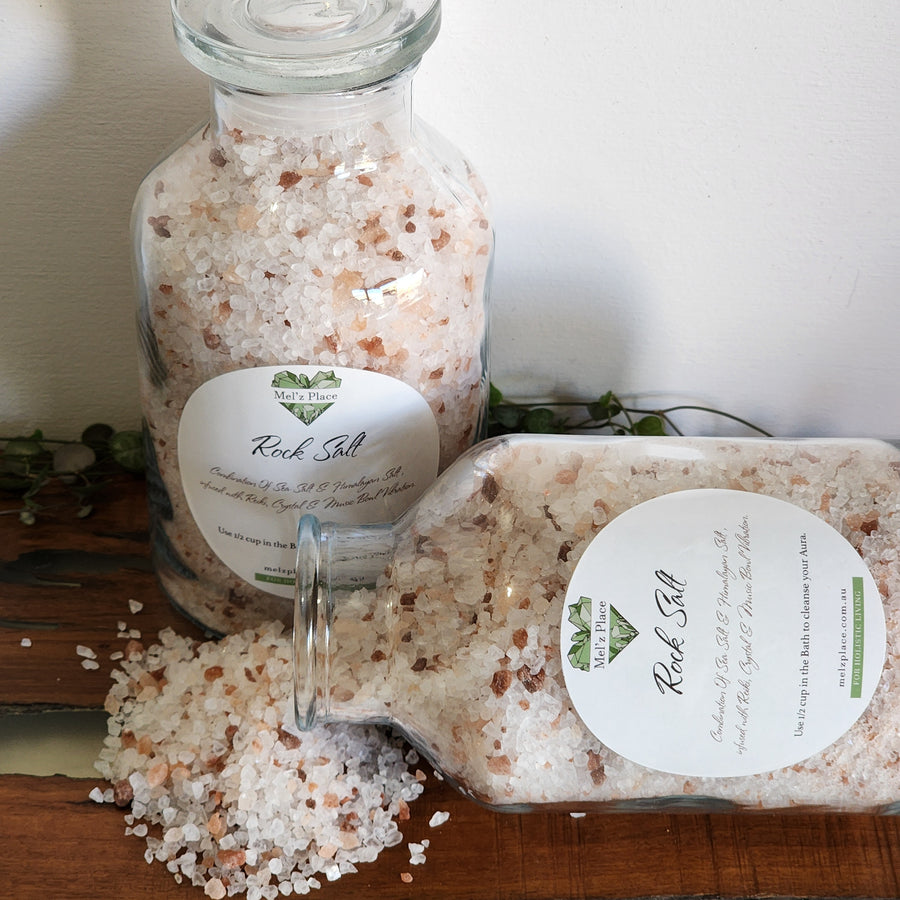Two glass containers of Rock Salt bath salts with a label on a wooden surface.