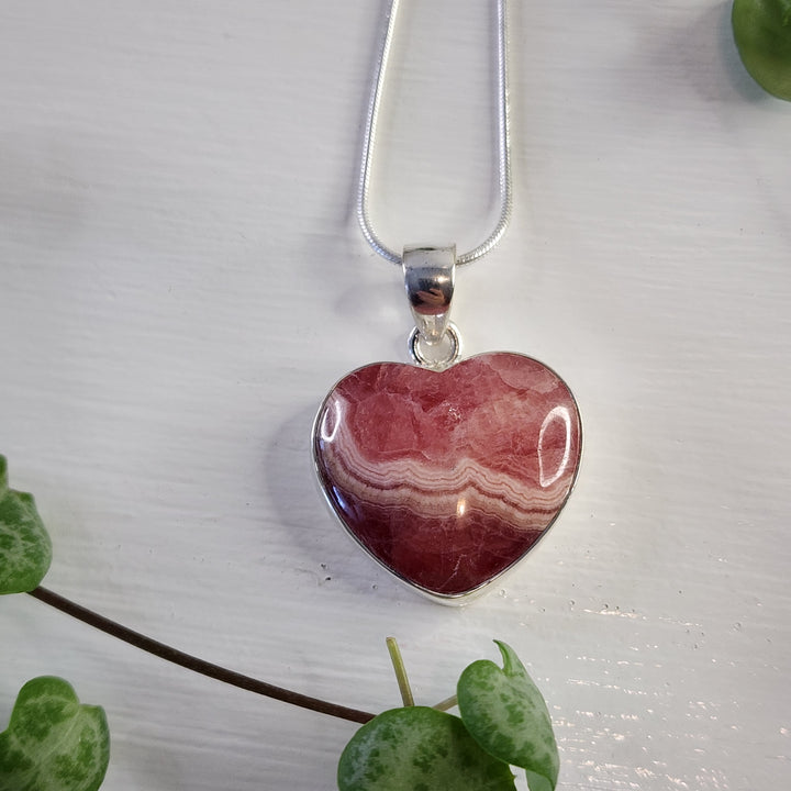 Rhodochrosite 21mm Heart Pendant.
Set in 925 Sterling Silver and comes with a 925 sterling silver chain.