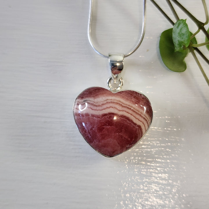 Rhodochrosite 21mm Heart Pendant.
Set in 925 Sterling Silver and comes with a 925 sterling silver chain.