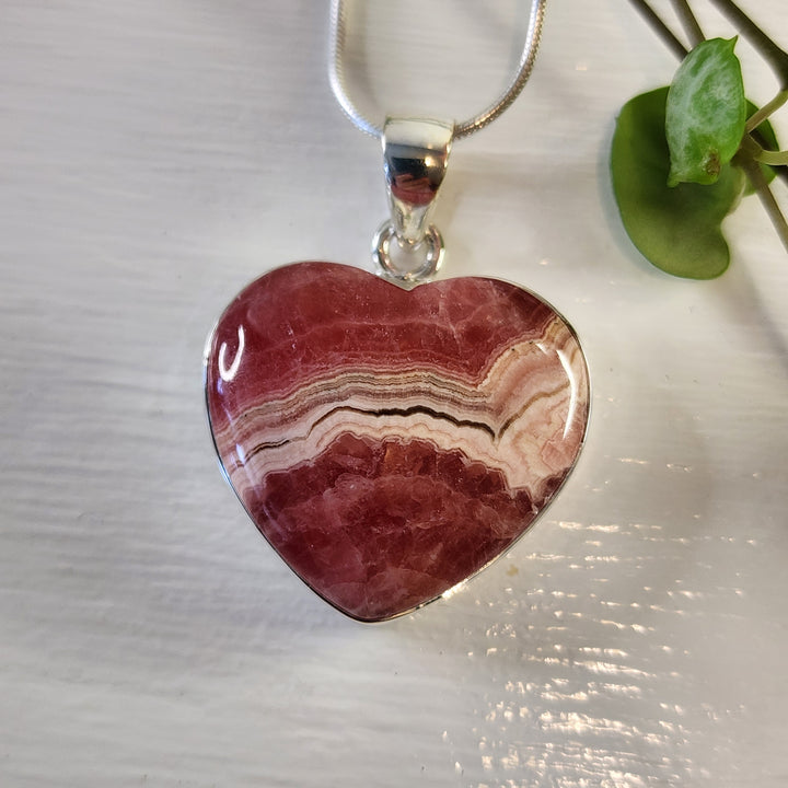 Rhodochrosite 21mm Heart Pendant.
Set in 925 Sterling Silver and comes with a 925 sterling silver chain.