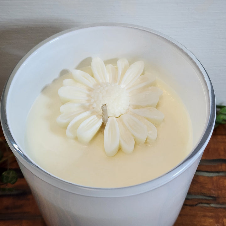 Large soy candle in coconut and lime scent with flower detail in wax.